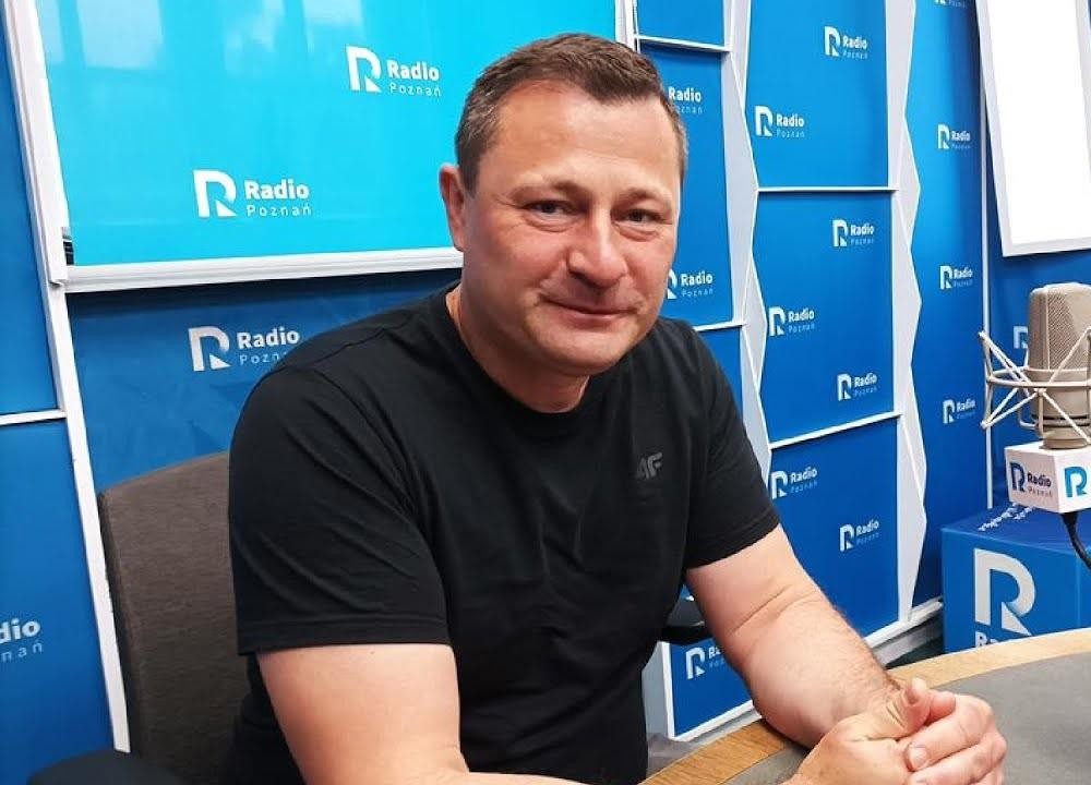 Krzysztof Paszyk podczas wystąpienia publicznego, z zamyśloną miną, symbolizujący jego zaangażowanie w kwestie polityczne i społeczne.
