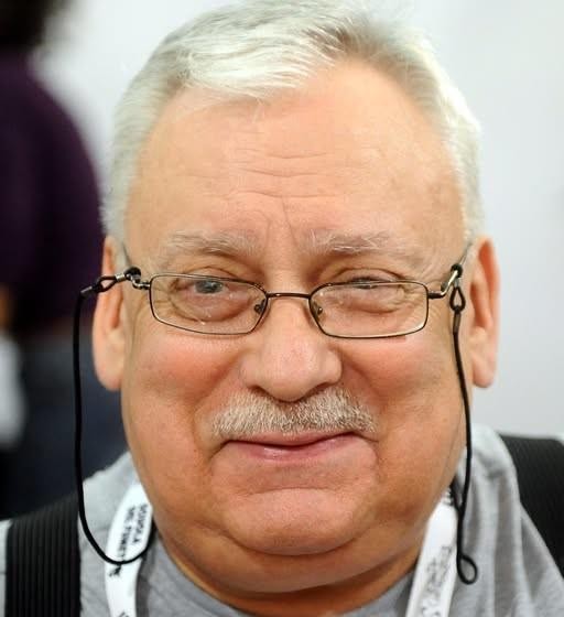Ilustracja Geralta z Rivii, głównego bohatera serii Wiedźmin, w dynamicznej pozie, oddająca mroczny klimat uniwersum.