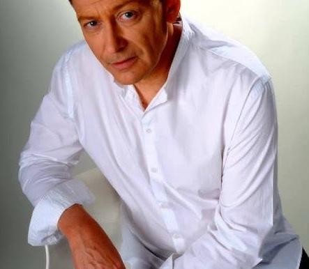 Jacek Borkowski na scenie podczas występu, ukazujący jego pasję i dynamikę jako artysty.