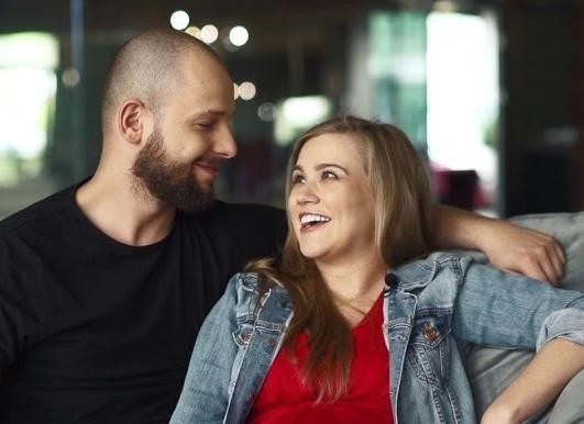 Maciej Pela w zamyślonej pozie, symbolizującej jego zaangażowanie w edukację taneczną, na tle studia.