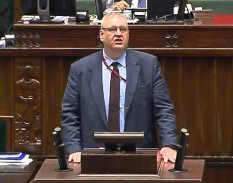 Bogdan Roman Święczkowski w dynamicznej pozie, oddającej jego autorytarny styl zarządzania i przydomek „Godzilla”.