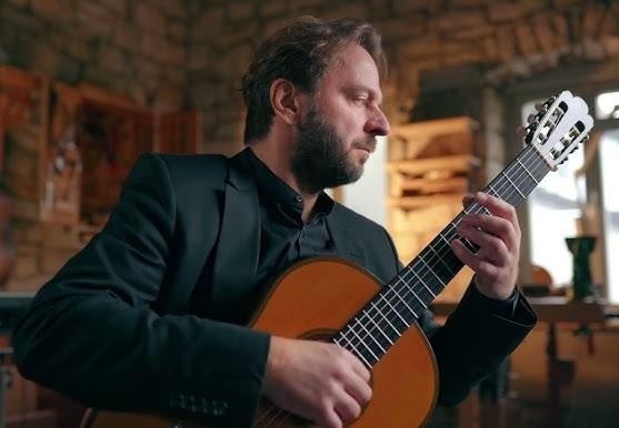 Marcin Dylla w trakcie emocjonującego występu na scenie, oddający się muzyce z pełnym zaangażowaniem.