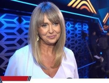Ewa Wachowicz w akademickim otoczeniu, zamyślona nad książką, symbolizująca jej wykształcenie i zaangażowanie w zarządzanie jakością.