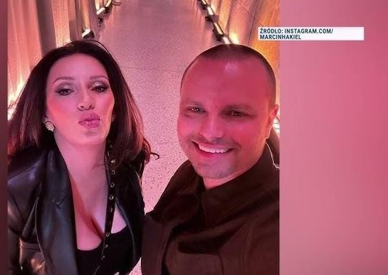Marcin Hakiel w dynamicznej pozie tanecznej w studio, ukazujący pasję i energię, z rozmazanym tłem.
