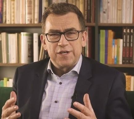 Maciej Orłoś prowadzący szkolenie z wystąpień publicznych, gestykulujący z charyzmą.