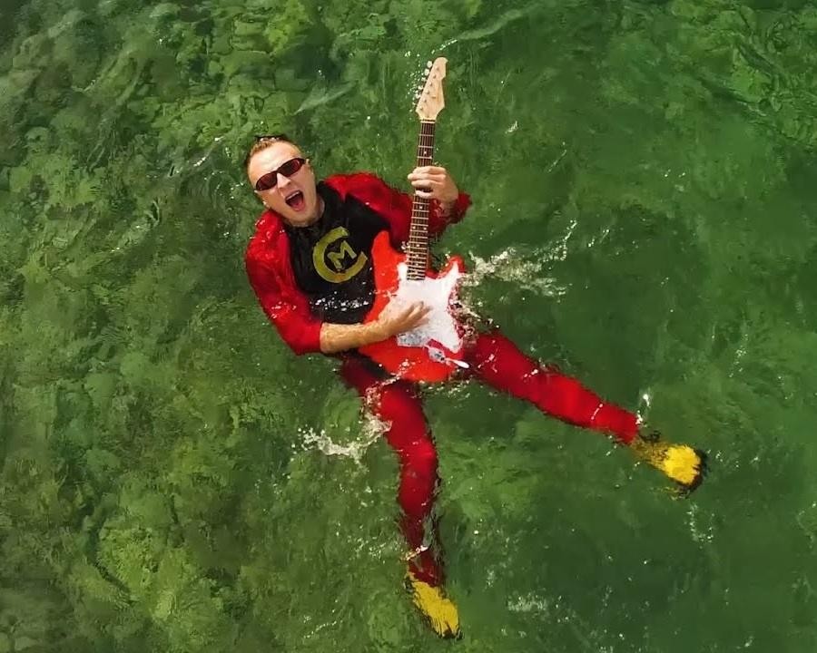 Czadoman w trakcie występu na żywo, na scenie, otoczony dynamicznymi światłami, oddający energiczną atmosferę koncertu disco polo.