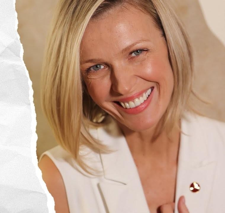 Magda Mołek na scenie telewizyjnej, pełna energii, w stylowej kreacji, w tle widoczne elementy studia.