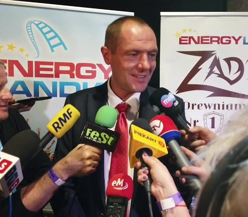 Marek Goczał za kierownicą rajdowego SSV w akcji, z kurzem w tle pustynnego krajobrazu.