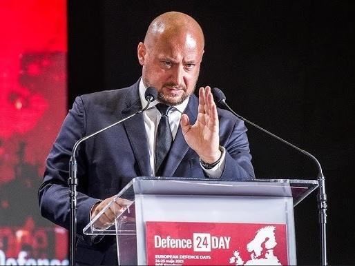 Jacek Zdzisław Siewiera w akcji, prawdopodobnie podczas wystąpienia lub spotkania, symbolizujące jego rolę lidera w dziedzinie bezpieczeństwa narodowego.